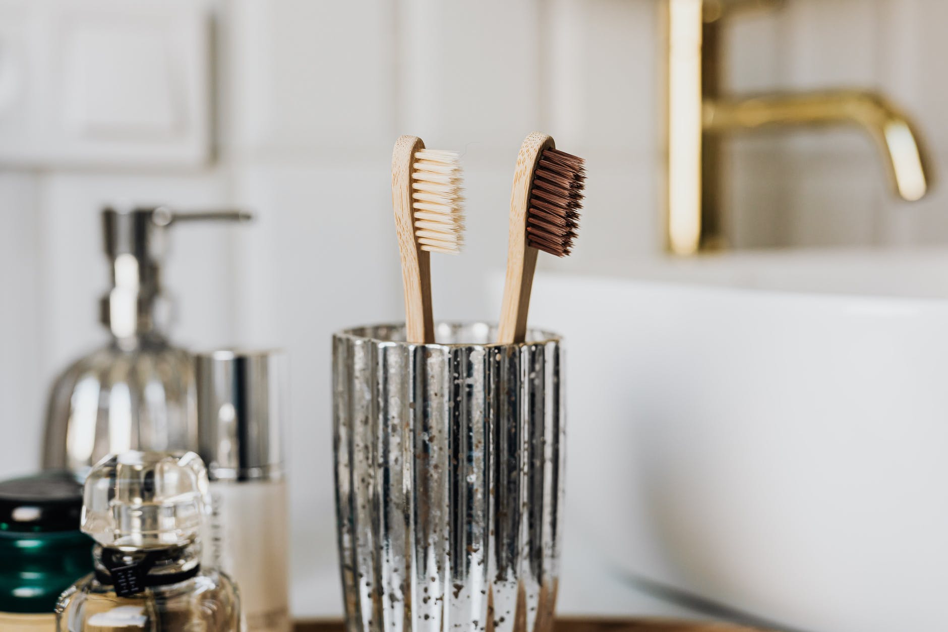 bamboo toothbrushes in glass in stylish bathroom